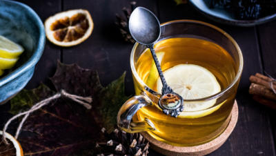 Cup of tea with lemon floating and spoon laid across the top